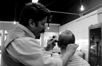 Peluquero cortandole el pelo a otro hombre - Injerto Capilar Asturias