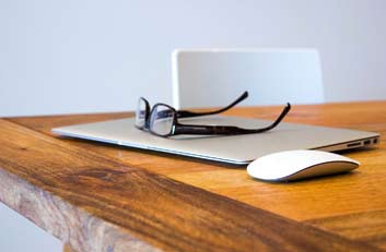 gafas sobre un ordenador que esta sobre la mesa - Injerto Capilar Gijón